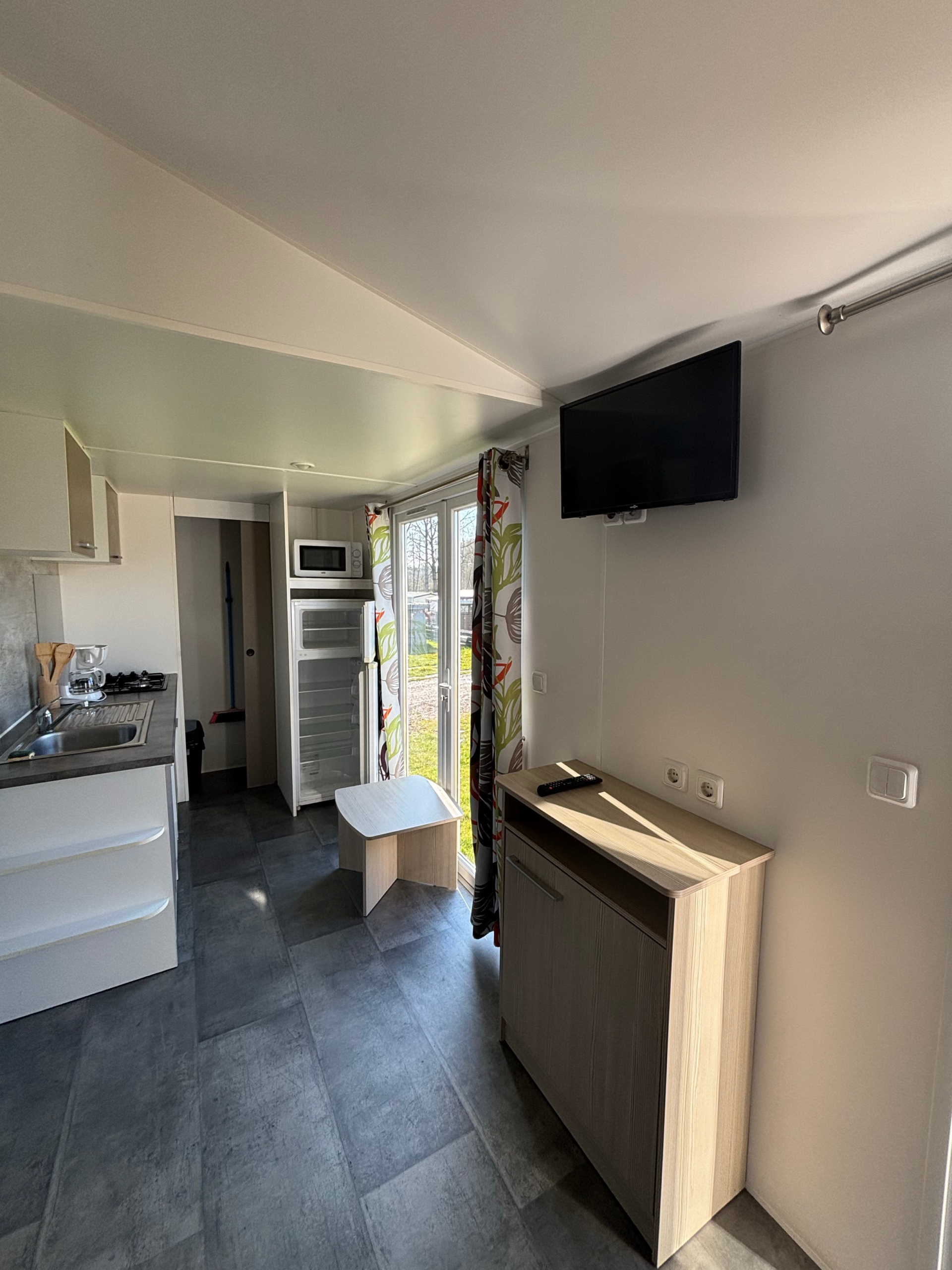 Photo du coin cuisine avec le coin télévision du mobil-home Cygne